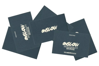 Scattered dark grey business cards featuring cream-colored typography for Onslow on a white background