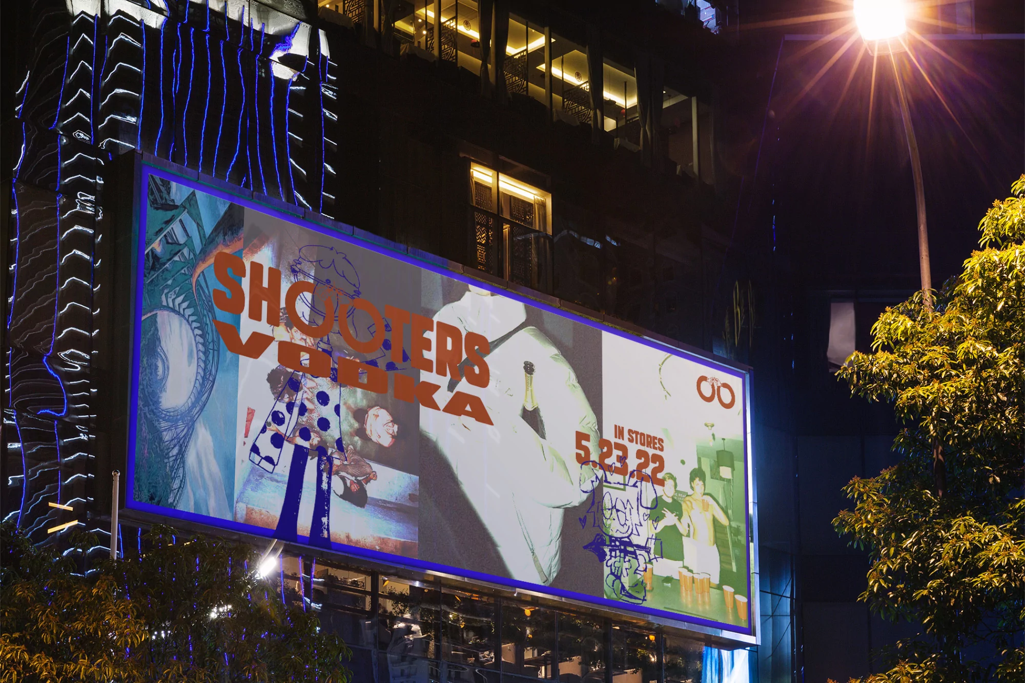 Nighttime view of a Shooters Vodka advertisement on a building in an urban environment, illuminated by a street lamp.