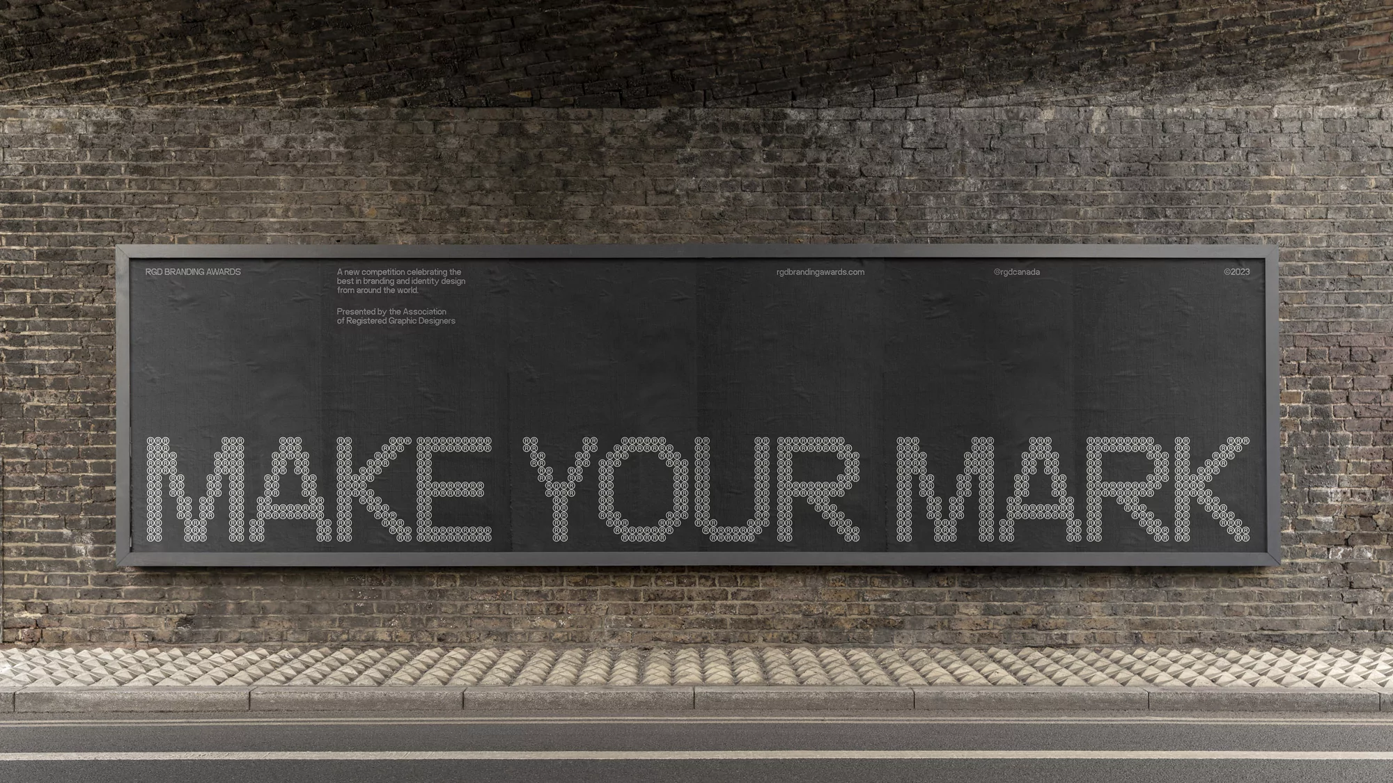 Outdoor advertising billboard on a brick wall displaying 'MAKE YOUR MARK' spelled out in small white circles for RGD Branding Awards.