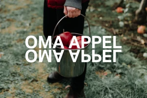 Person holding a metal bucket filled with fresh red apples in an orchard setting with white typography overlaid