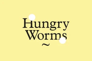 Graphic design brand identity featuring black serif typography reading Hungry Worms on a pale yellow background.