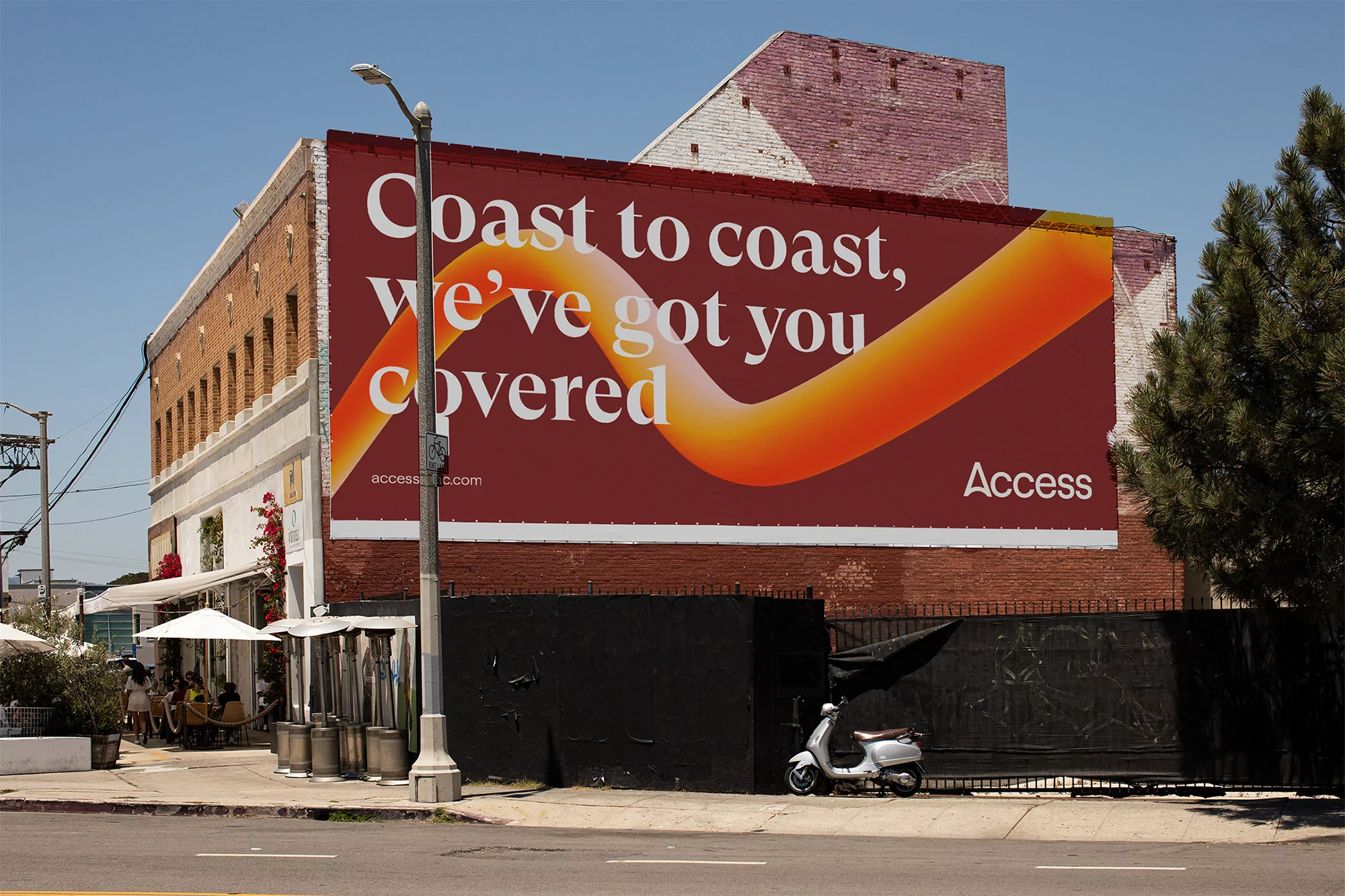 Outdoor billboard on a brick building with the text 'Coast to coast, we've got you covered' and an orange design element.
