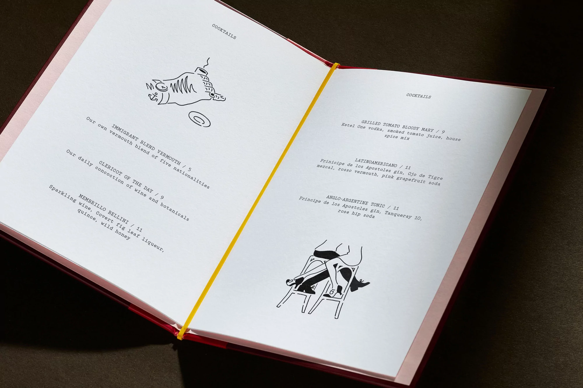 An open cocktail menu features black line drawings with drink names, prices, and ingredients on a dark background.