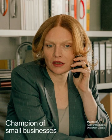 Professional woman in pinstripe suit on a phone call in an office setting. Businesswoman with auburn hair. Office interior background.