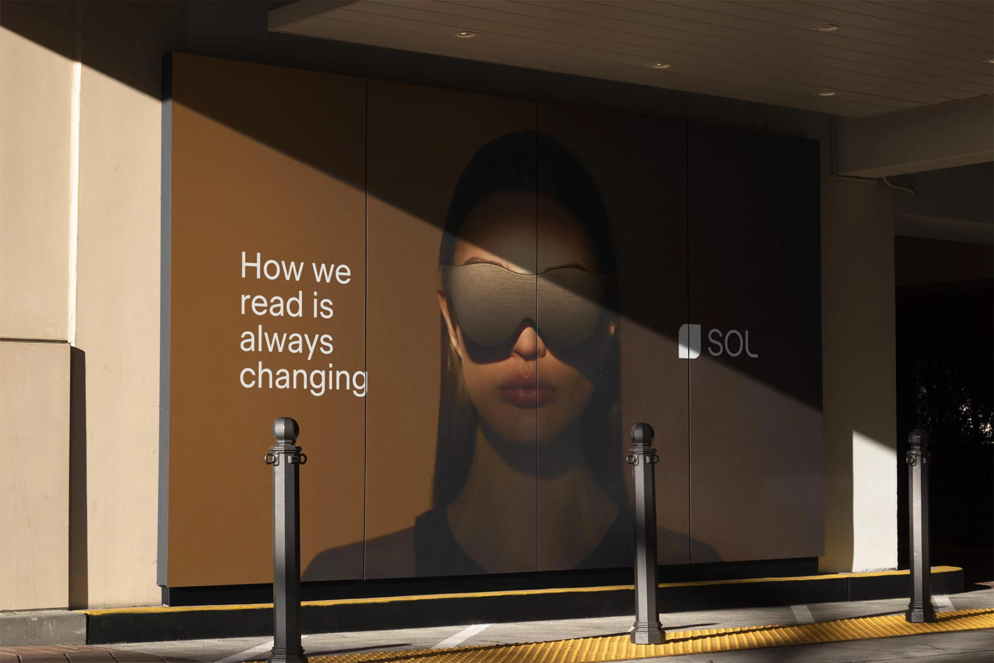Outdoor billboard ad featuring a woman wearing sleep shades next to text that reads, 'How we read is always changing,' and the logo for SOL.