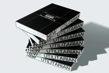 A towering stack of black books with bold white typography on their spines against a neutral background.