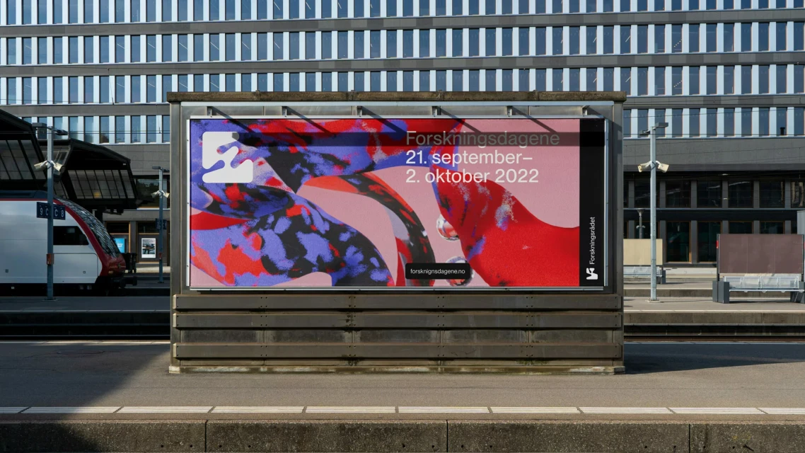 Outdoor advertising billboard with abstract art at a train station. The poster features an abstract design and text promoting research.