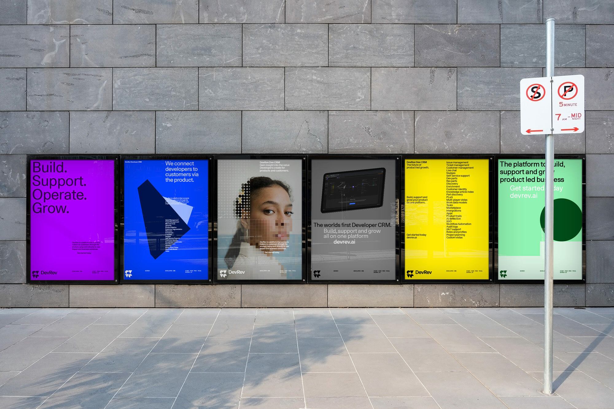 Six advertising posters on a stone wall, featuring branding and text against backgrounds of purple, blue, neutral, yellow, and green.