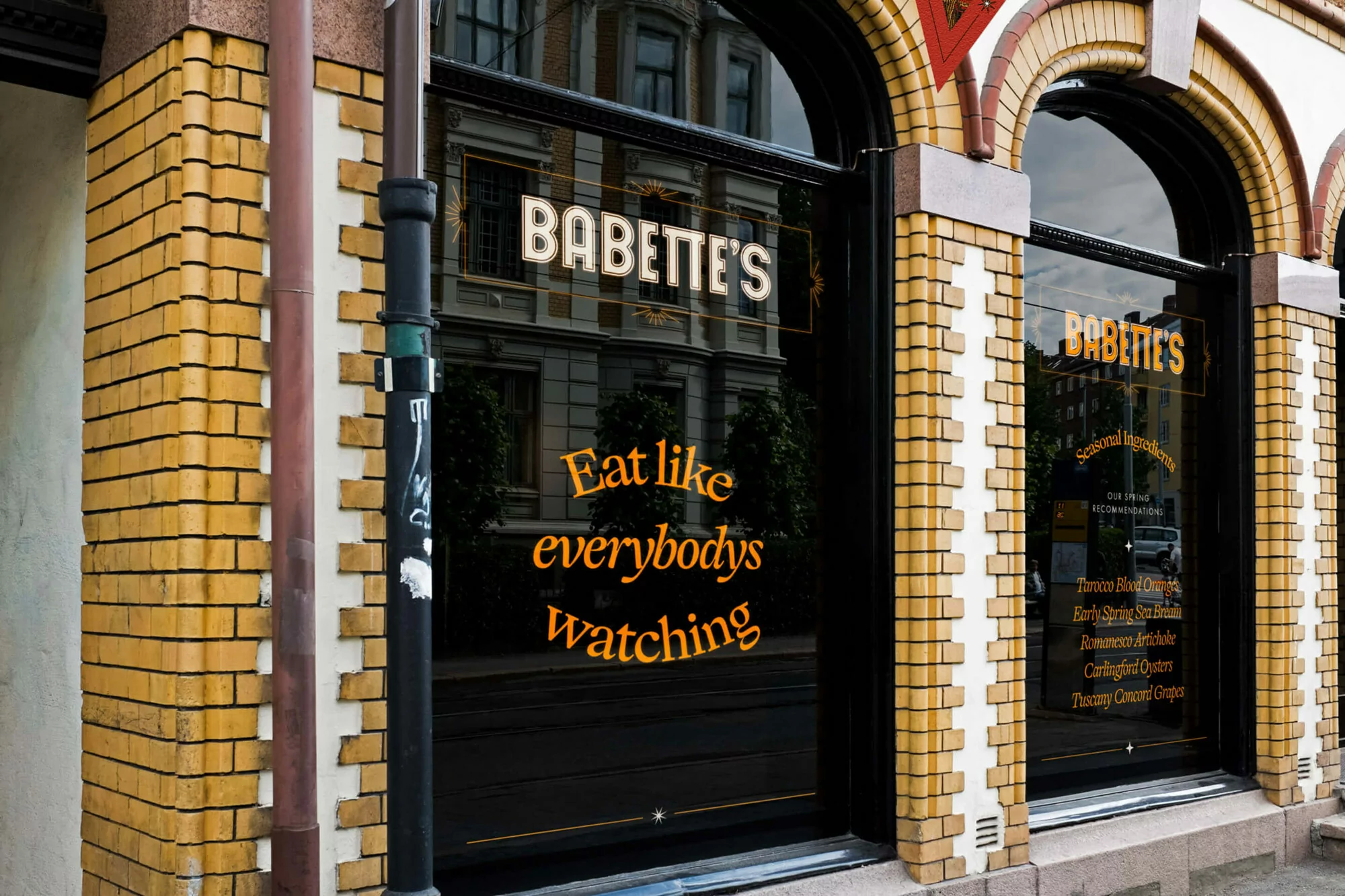 Exterior view of Babette's restaurant with reflective windows displaying text and a glimpse of the building across the street.