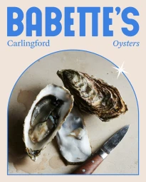 Fresh oysters and an oyster knife arranged on a neutral surface with blue typographic branding overhead