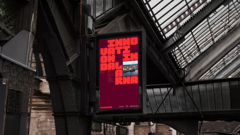 Outdoor advertising poster featuring the text 'Innovation Dalarna' with an inset image, mounted on a dark metallic structure.
