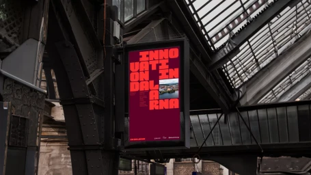 Digital advertisement screen displaying bold red typography and branding for Dalarna mounted in a transit station
