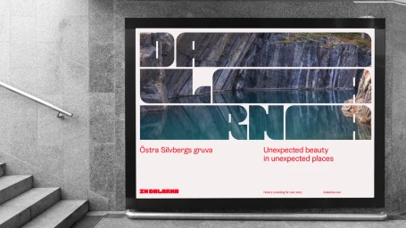 Billboard displaying Dalarna brand identity on a grey stone wall next to concrete stairs