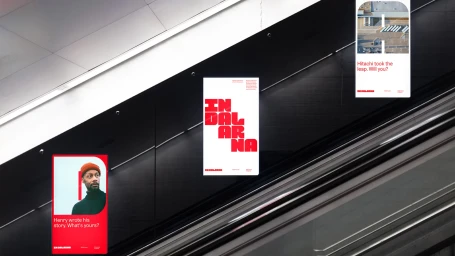 Three promotional posters for Dalarna featuring bold red typography and imagery displayed along a modern escalator wall.