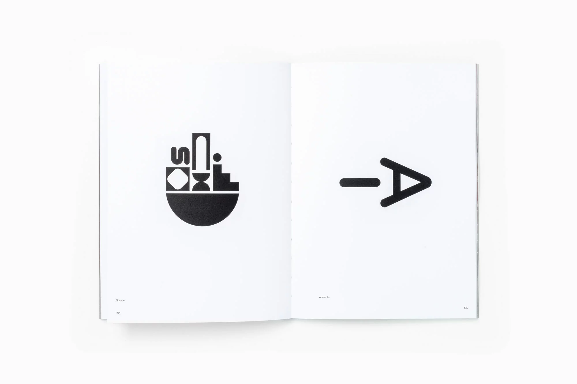 Open book featuring abstract geometric shapes and typography in a minimalist black and white design. Clean, modern graphic design.