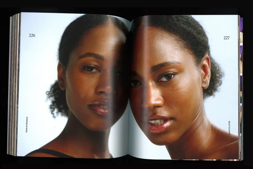 Open magazine spread features close-up portraits of two Black women with natural hair and minimal makeup against a light background.