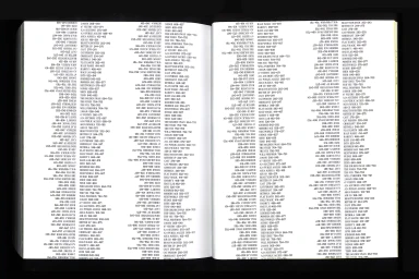Open book spread showing dense columns of printed typographic index entries and page numbers against a dark background