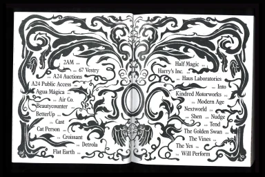 An open book displaying an intricate black and white illustrated table of contents with elaborate decorative floral borders.