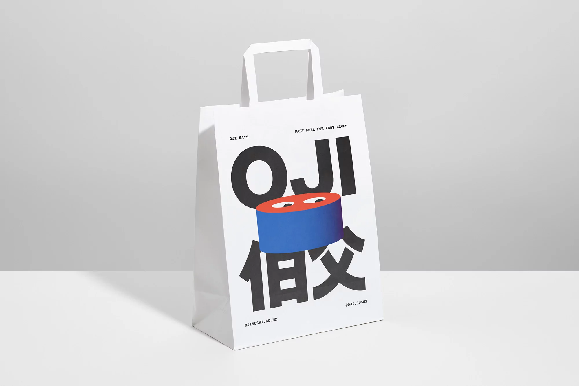 Graphic image of a white shopping bag with a blue and orange graphic design, standing against a pale gray background in a studio setting.