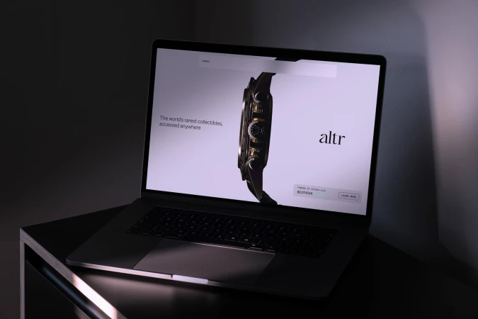 Laptop displays luxury watch marketplace 'altr' against a dark gray backdrop, offering a glimpse into digital luxury retail.