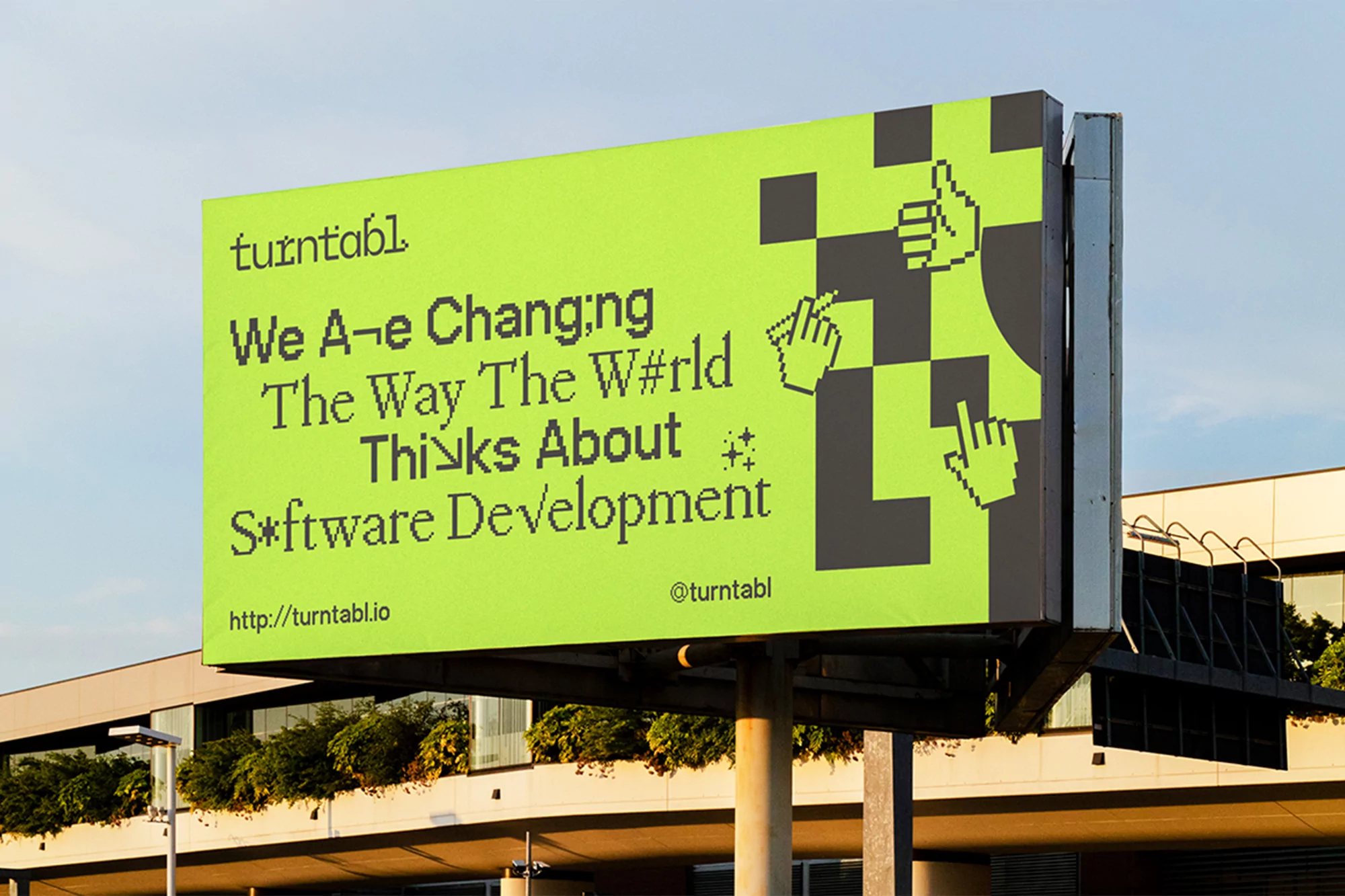 Billboard for Turntabl with lime green background and digital-style hands, promoting software development, on a sunny day with building background.