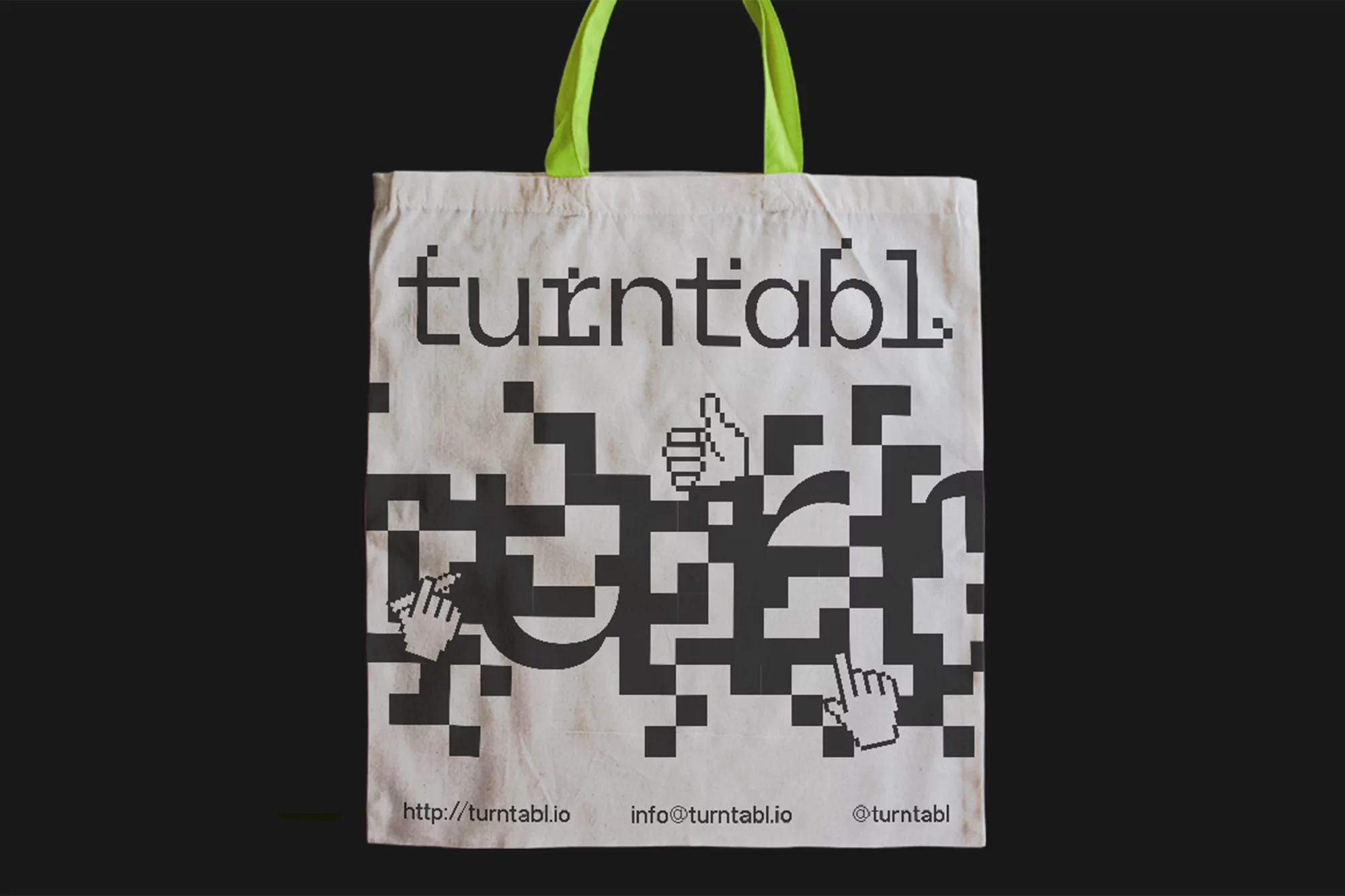 Tote bag with the brand name turntabl and digital-style graphics against a dark background, focusing on the bag's design.