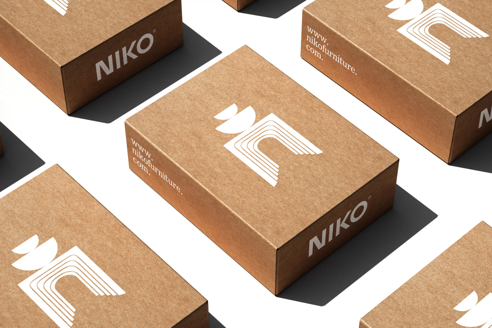 Close-up of multiple cardboard boxes with a white logo and text, arranged on a white surface with shadows.