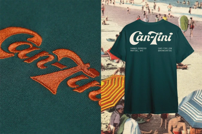 Dark teal t-shirt with a white logo on a split background of embroidery and a vintage beach scene. Casual summer style.