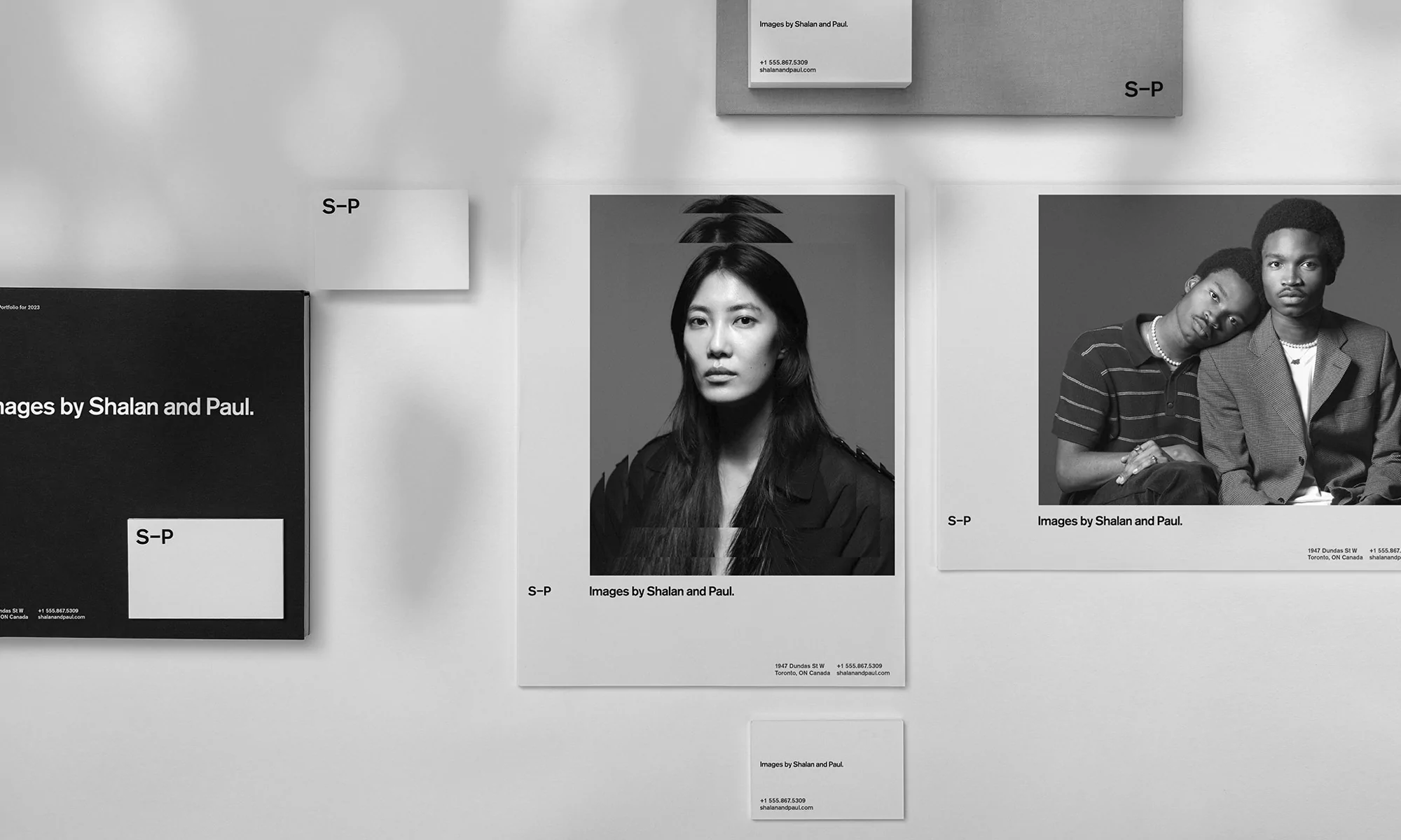 Black and white photographs of two portraits and a book cover featuring the text 'Images by Shalan and Paul' on a white wall.