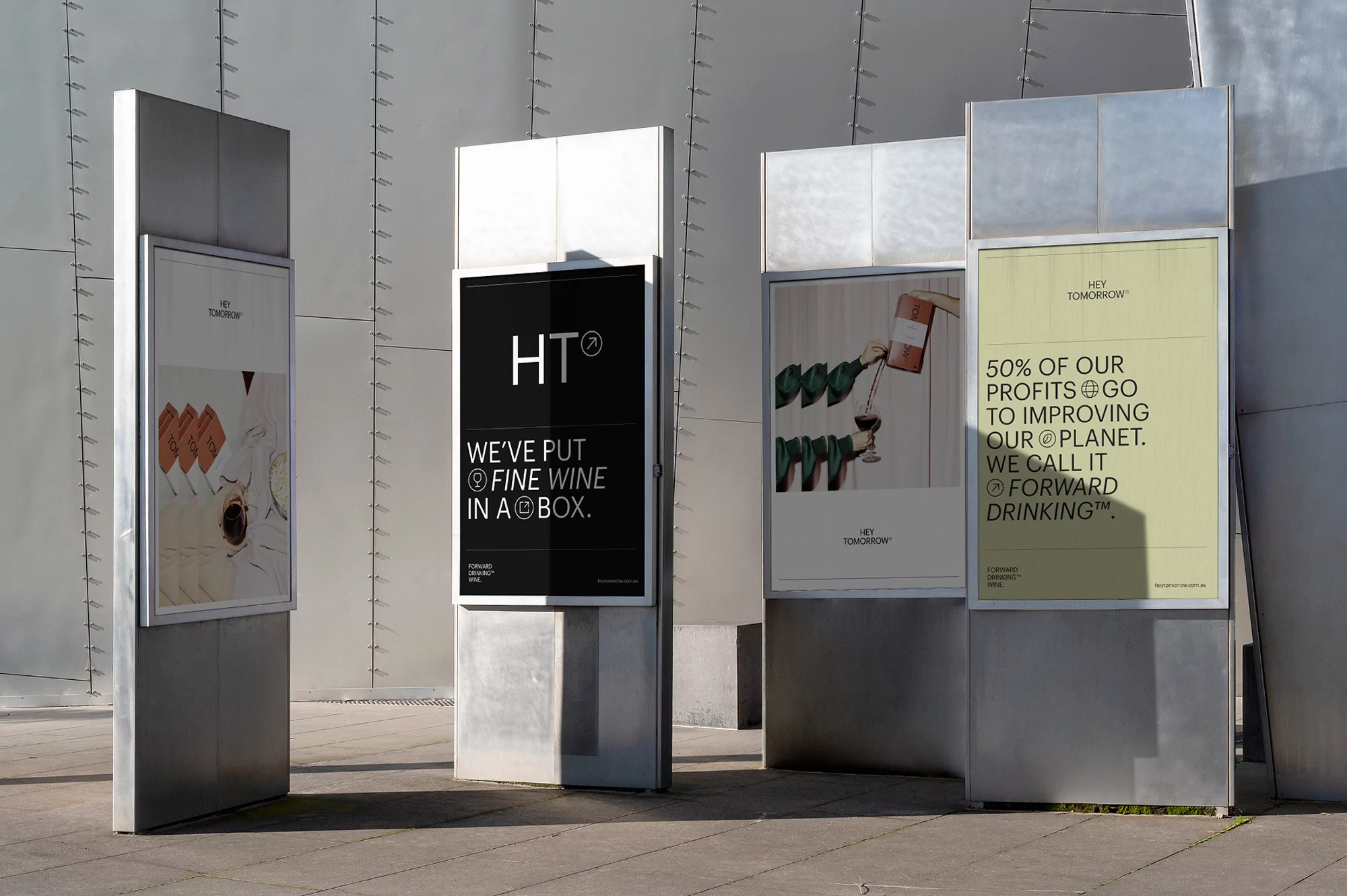 Outdoor advertising showcases sustainable wine brand 'Hey Tomorrow' with taglines about boxed wine and improving the planet.