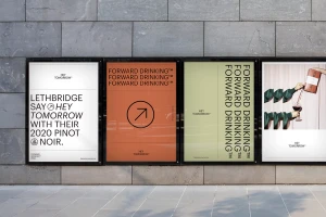 Four printed posters displayed on a grey stone exterior wall showcasing graphic branding for Hey Tomorrow with typography and imagery.