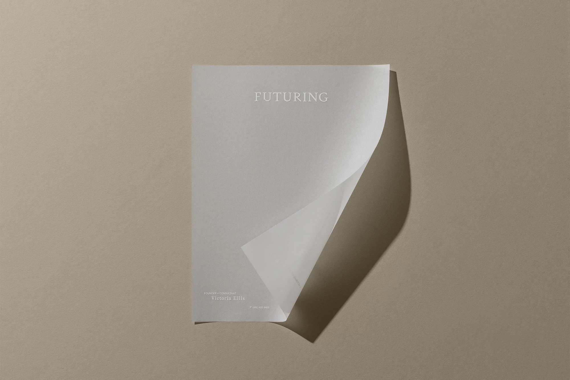 Minimalist studio shot of a white paper with the word 'Futuring' on a beige background, showcasing a clean, modern design aesthetic.