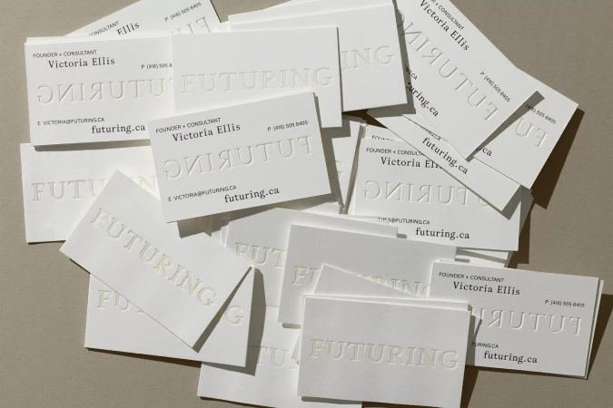 Stack of clean, white business cards arranged closely on a neutral surface, conveying a sense of professionalism and minimalist design.