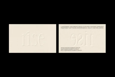 Two cream-colored textured paper business cards with debossed typography set against a solid black background.