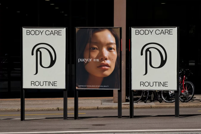 Outdoor advertising displays featuring body care product branding with a woman's portrait and a bicycle parked nearby.