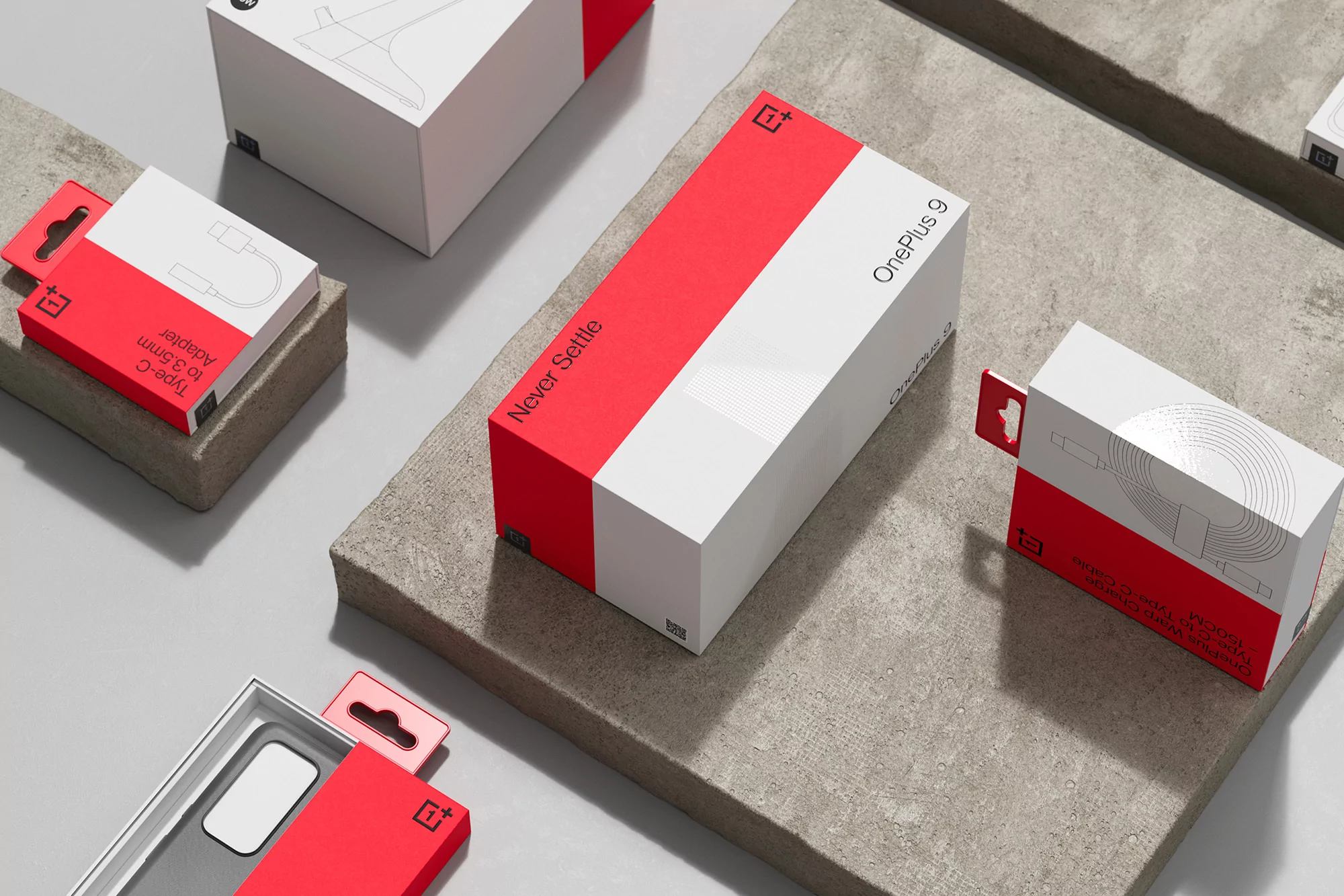 OnePlus smartphone and accessories product boxes in red and white on grey textured surface, studio product photography.