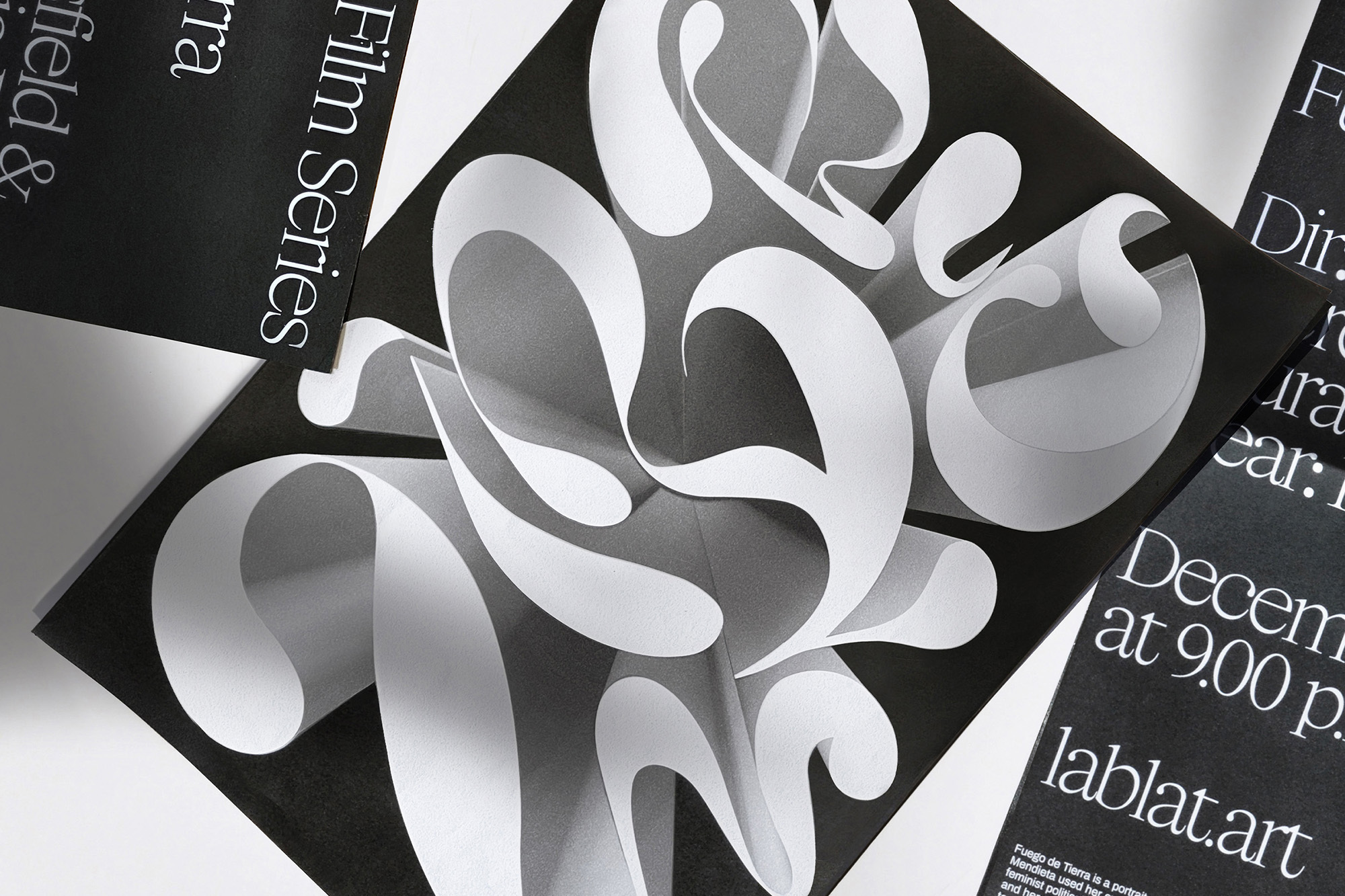 Abstract graphic design featuring curved, paper-like shapes on black, surrounded by film series posters with white text details.