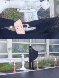 Model wearing a long black coat and holding a light pink handbag next to a white humanoid robot outdoors