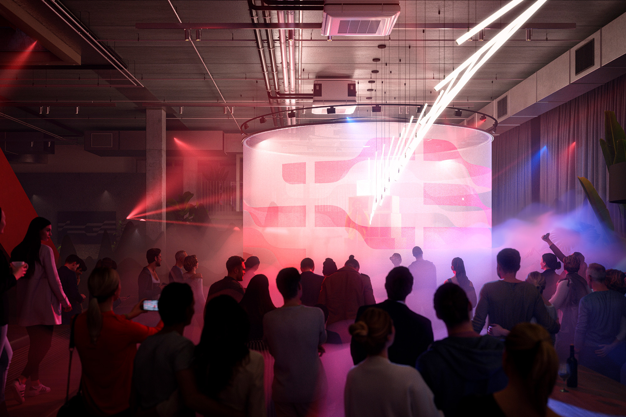 Large group of people gather in an indoor event space illuminated with red and blue lights, featuring a circular display screen.