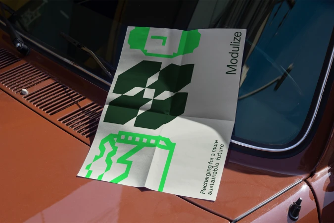 Promotional poster with green graphics on a brown car hood, featuring the text 'Modulize' and promoting sustainable future ideas.