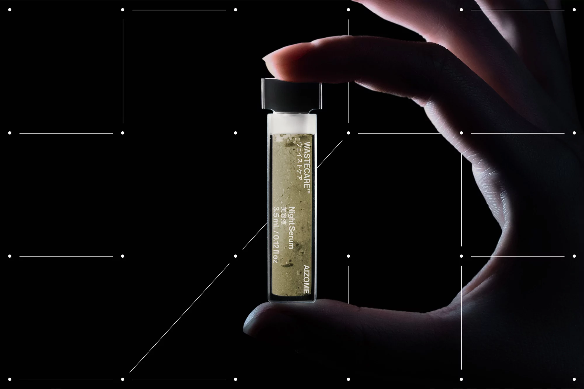 Hand holding a glass vial of night serum, beauty product for skincare with a black screw top, on a dark background. Studio shot.