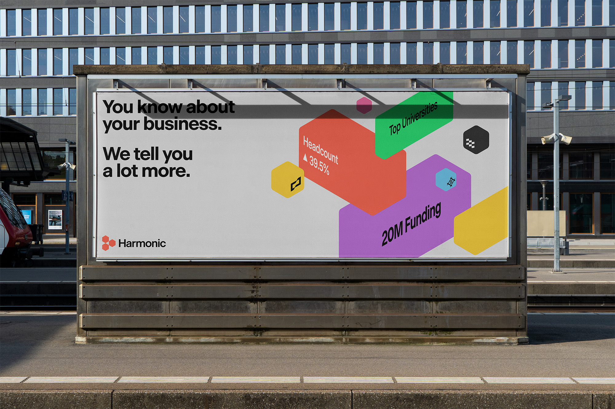 Outdoor advertising billboard with colorful graphic about business, including Headcount, Top Universities and 20M Funding.