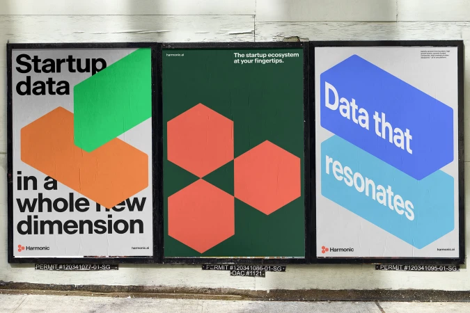 Three marketing posters displayed on a wall. Each poster features modern graphic design with geometric shapes and bold text. 