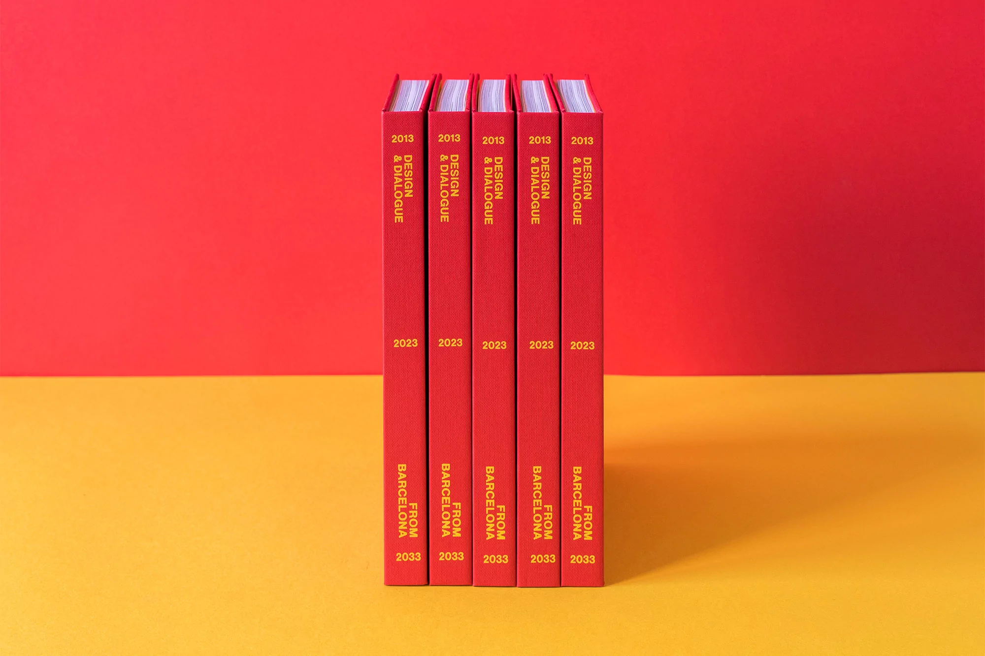 Five red books stand side by side, their spines visible, featuring yellow text on a red and yellow background.