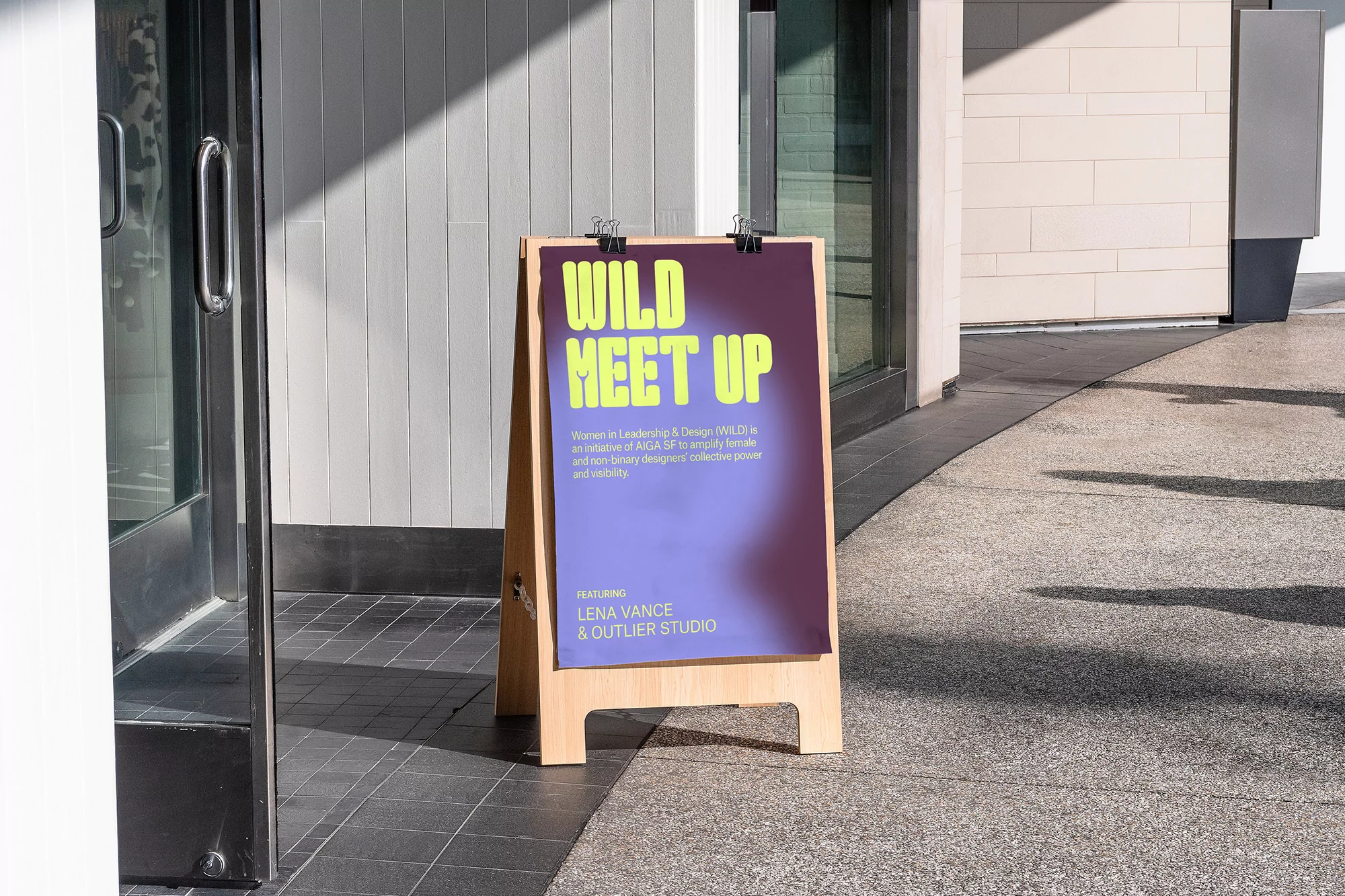 Outdoor shot of a sandwich board sign with the words WILD MEET UP, advertising Women in Leadership & Design WILDE event.