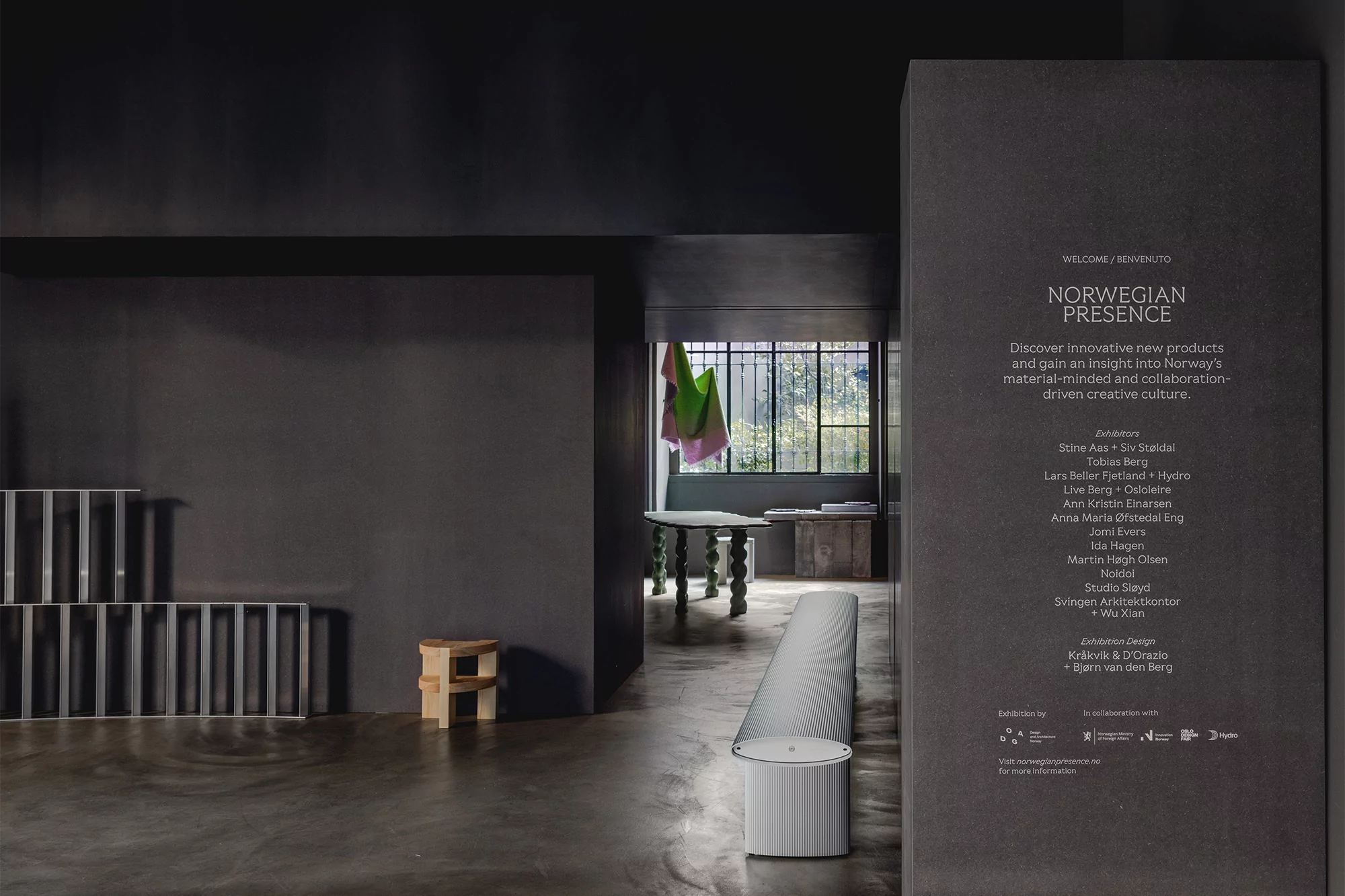 Contemporary interior featuring modern furniture displayed in a minimalist exhibition space with polished concrete floors and grey walls.