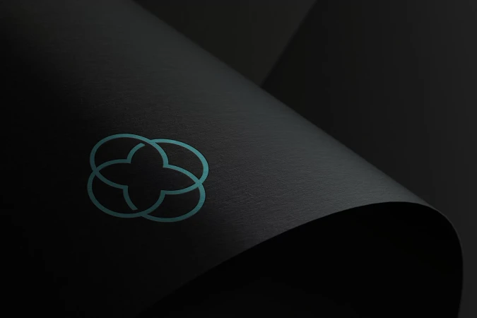 Abstract clover-shaped design on a dark surface with subtle shadows, creating a minimalistic and elegant visual composition.