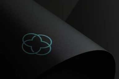 Teal interlocking clover logo on dark curved textured black paper background