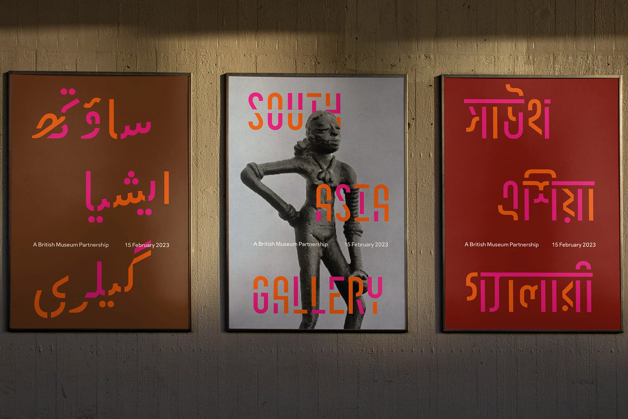 Museum exhibit posters on a wall featuring South Asian art and culture with text in multiple languages and statue imagery.