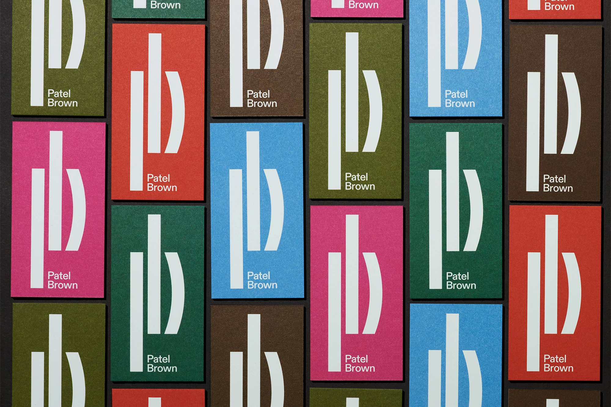 Collection of colorful business cards with a modern, abstract logo and the text 'Patel Brown' arranged in a graphic pattern.